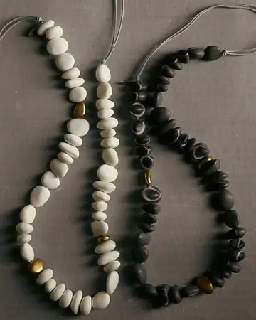 Stylish black and white beaded necklaces with gold accents for women.